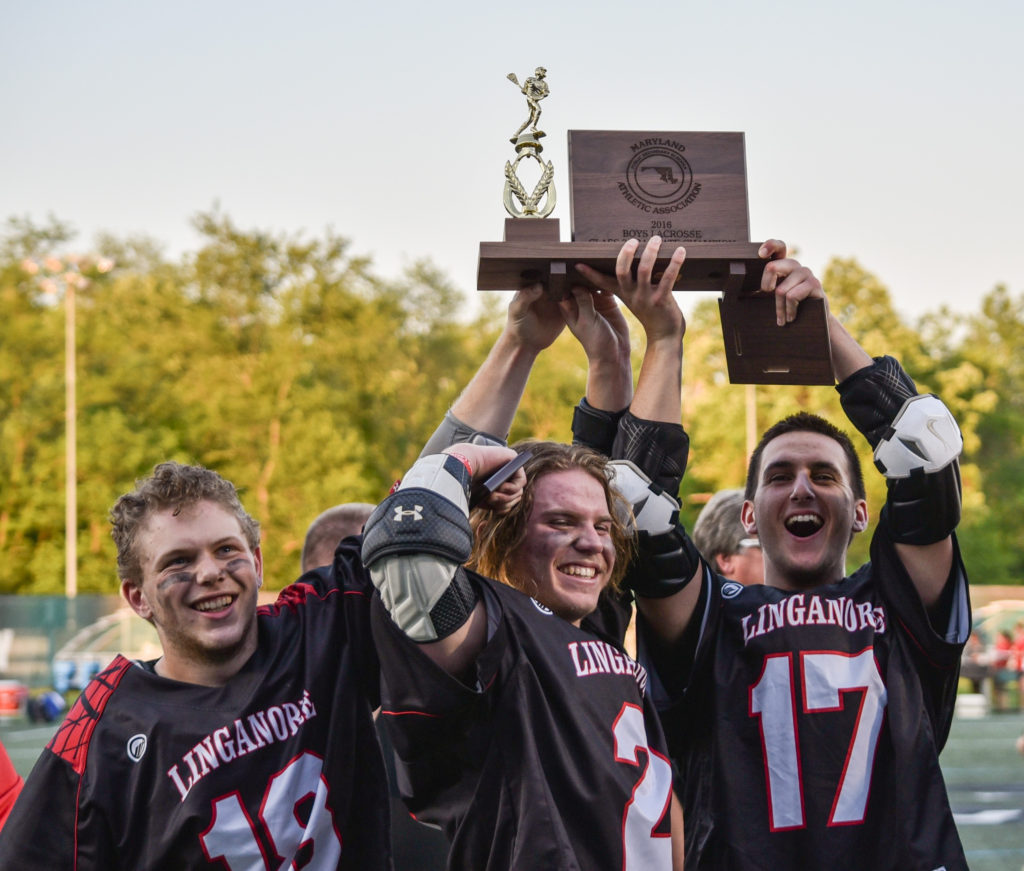 Left to right: Anthony Sparacino, Daniel Murphy, and Daniel Ross hoist the Class 3A/2A state championship plaque Tuesday evening at Stevenson University. Photo taken by Alycia Weaver/Maryland Sports Access.